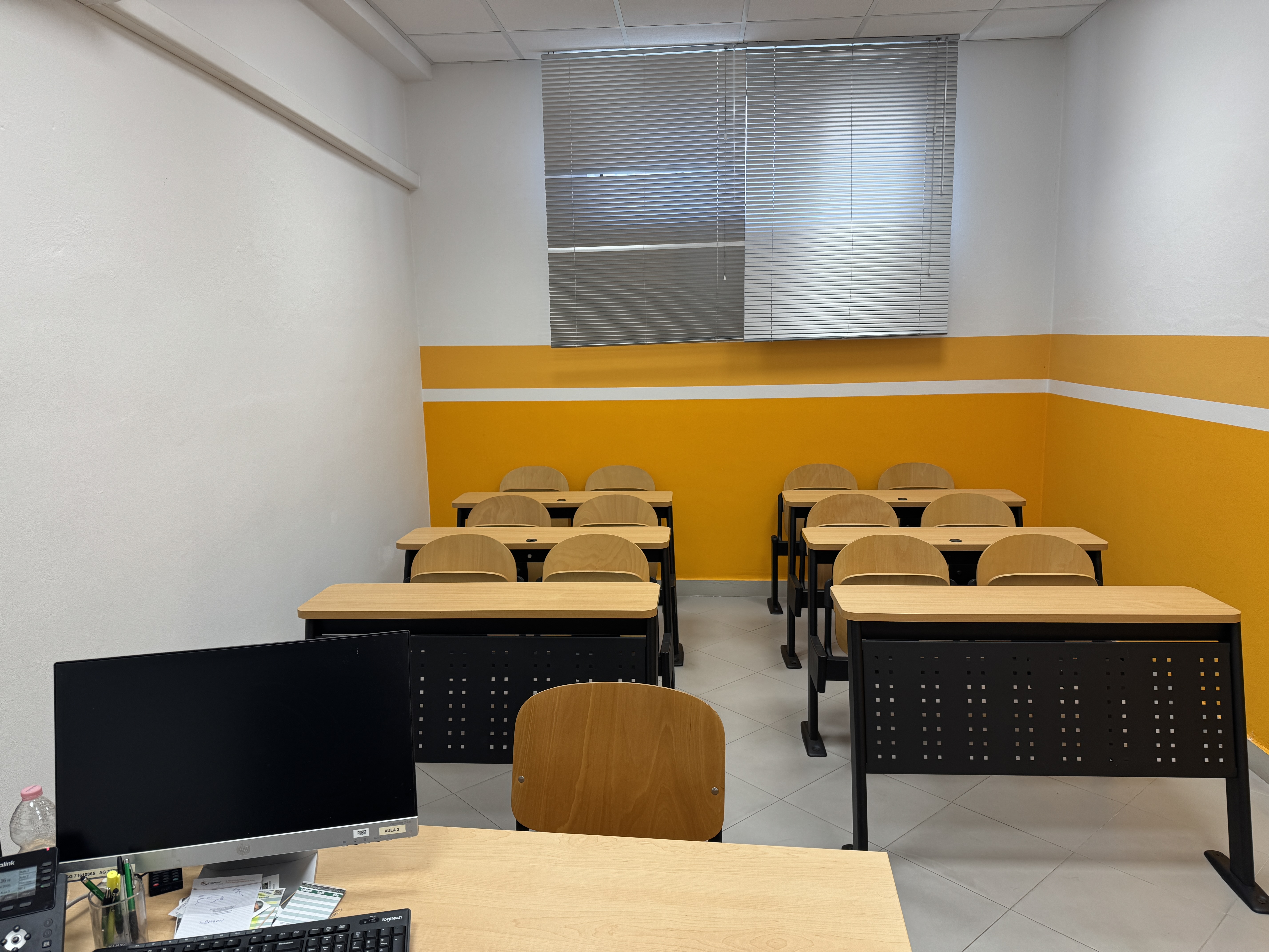 Vue de la salle de classe 3 depuis le bureau du professeur en direction des tables.